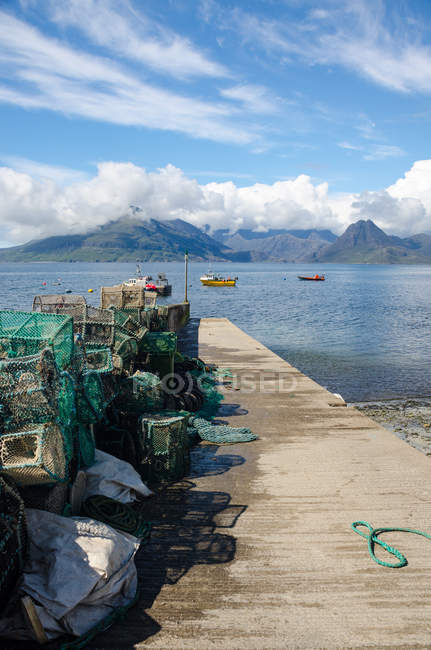 United Kingdom, Scotland, Highland, Isle of Skye, fishing net on pier and boats in Port of Elgol — Stock Photo