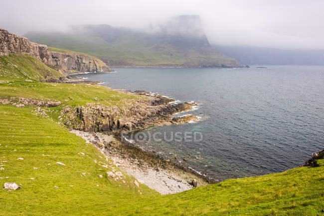 Scozia, Highlands, Isola di Skye, Glendale, Neist Point, Paesaggio costiero panoramico con rocce verdi in tempo nebbioso — Foto stock