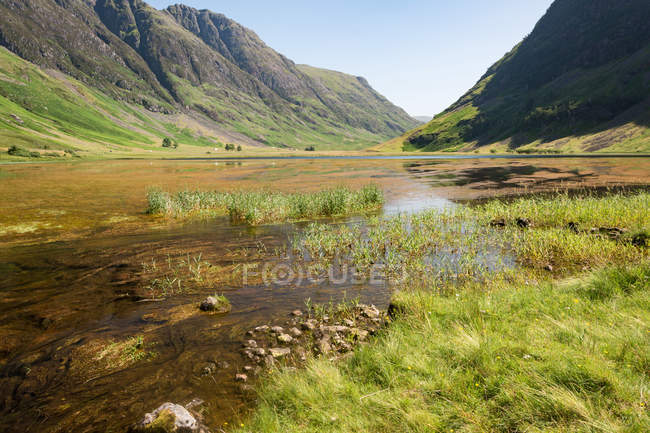 United Kingdom, Scotland, Highland, Ballachulish, Lake in Glencoe Highland scenic landscape with green meadow and mountains — Stock Photo