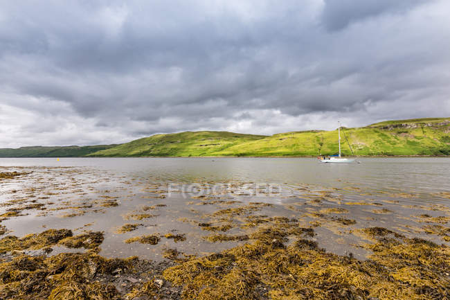 Reino Unido, Escocia, Highland, Isla de Skye, Carbost, Nubes oscuras ver montaña lago paisaje - foto de stock