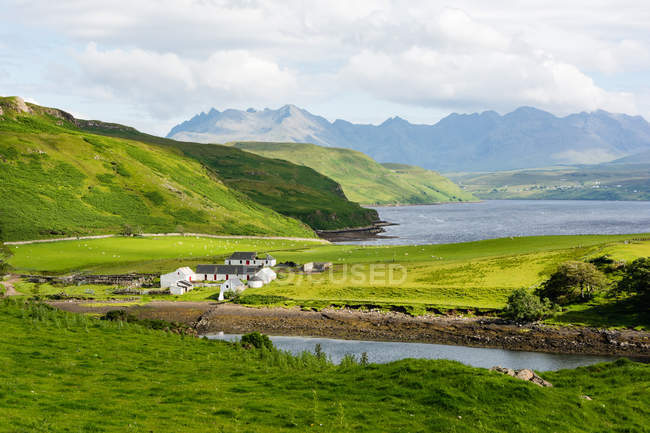 Regno Unito, Scozia, Highland, Isola di Skye, Veduta sulla baia di Gesto, Paesaggio naturale verde con villaggio vicino al lago di montagna — Foto stock