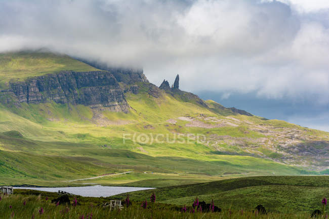 Royaume-Uni, Écosse, Highlands, Île de Skye, Portree, At Old Man of Storr, Trotternish, paysage de montagnes pittoresque avec des roches et un lac par temps brumeux — Photo de stock
