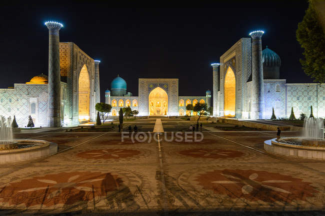 Узбекистан, Самаркандская область, Самарканд, площадь Регистан с дворцом, освещенным ночью — стоковое фото