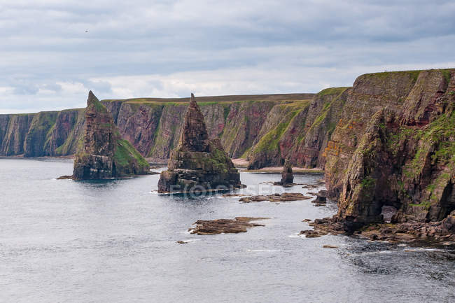 Royaume-Uni, Écosse, Highland, Wick, Duncansby Head avec ses formations rocheuses dentelées et ses aiguilles rocheuses au bord de la mer — Photo de stock