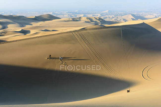 Dunes de sable hautes avec des gens occasionnels près de l'oasis de Huacachina, Ica, Pérou. — Photo de stock