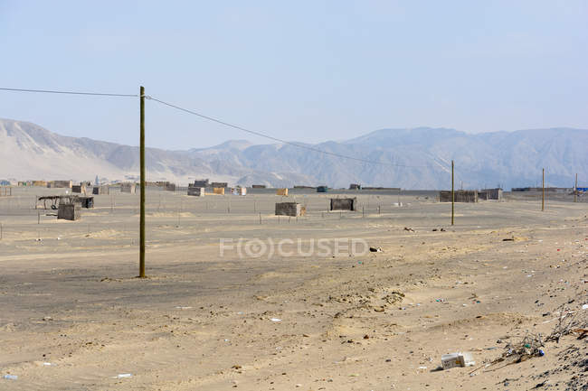 Peru, Ica, Nasca, Nazca, Paisagem deserta com cabanas e montanhas no fundo — Fotografia de Stock