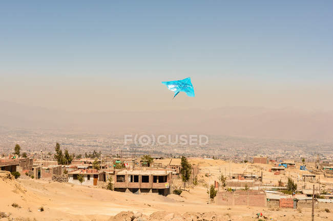 Peru, Arequipa, flying kite over poor city district — Stock Photo