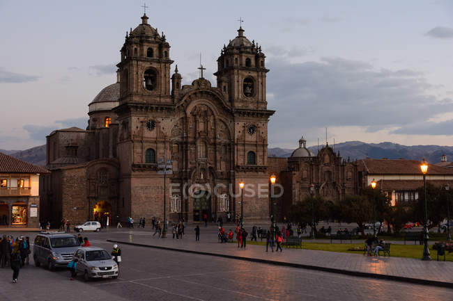 Perú, Cusco, coches y gente en la calle de la ciudad al atardecer - foto de stock