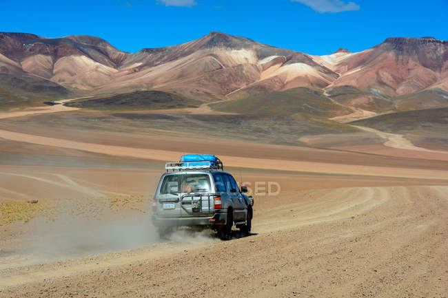 Bolivia, Departamento de Potosi, rear view of car driving by  Montana Colorada — Stock Photo