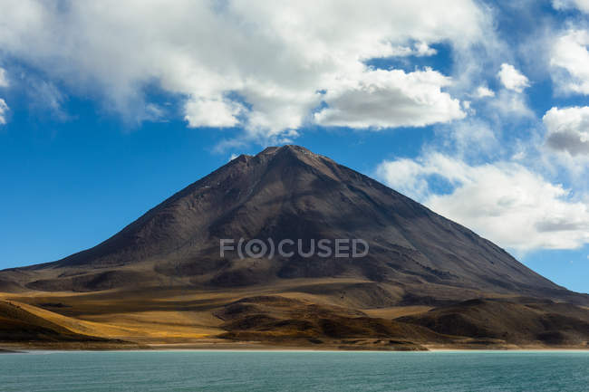 Bolívia, Vulcão Licancabur junto ao lago na fronteira entre Bolívia e Chile — Fotografia de Stock