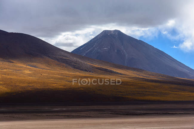 Paisaje abandonado con volcán Licancabur en la frontera entre Bolivia y Chile - foto de stock