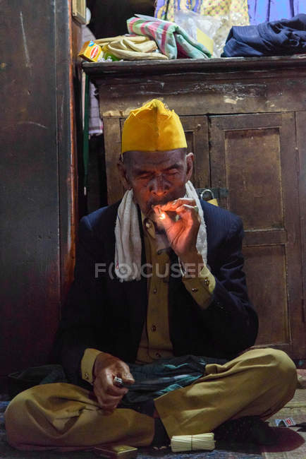 Portrait of smoking Asian man in room, Kabubaten Karo, Sumatera Utara, Indonesia — Stock Photo