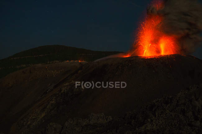 Indonesia, Maluku Utara, Kabupaten Halmahera Barat, volcán activo Ibu brillando por la noche en el norte de Molikken - foto de stock