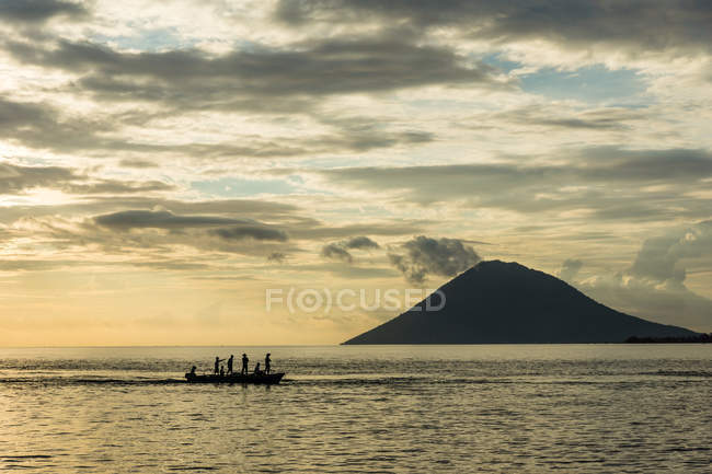 Indonesien, Sulawesi Utara, Kota Manado, Menschen auf einem Boot auf Sulawesi Utara bei Susnet, Berg im Hintergrund — Stockfoto