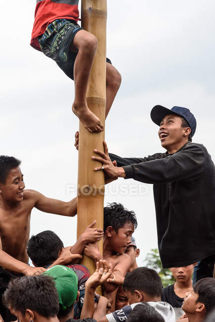 KABUL BULELENG, BALI, INDONESIA - AUGUST 17, 2015: Teenagers from village climbing on greased wooden pole — Stock Photo