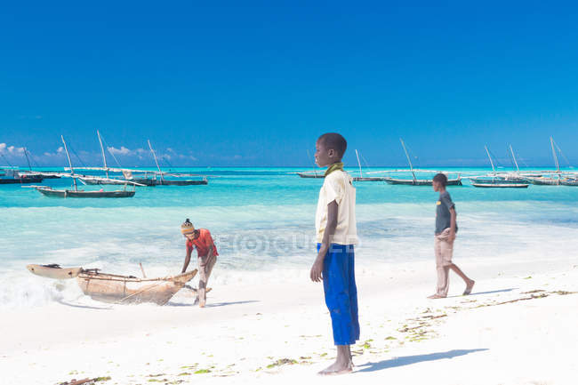 Tanzanie, Zanzibar, Nungwi, garçons avec des bateaux sur la plage — Photo de stock