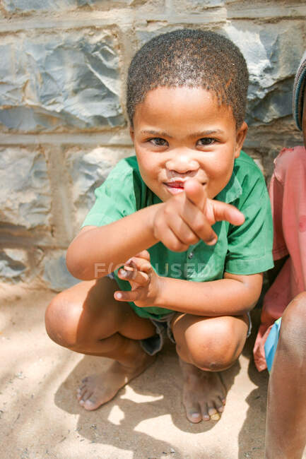 Namibia, Karas, Keetmanshoop, Local Boy, bambino allegro che punta con il dito contro la macchina fotografica sulla strada — Foto stock