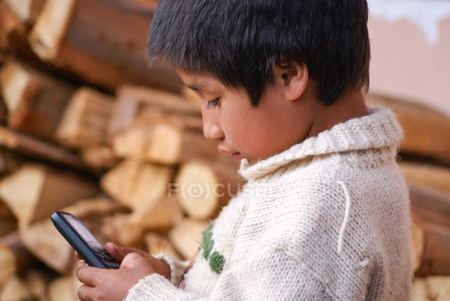 Perú, Urubamba, niño jugando con el teléfono móvil - foto de stock