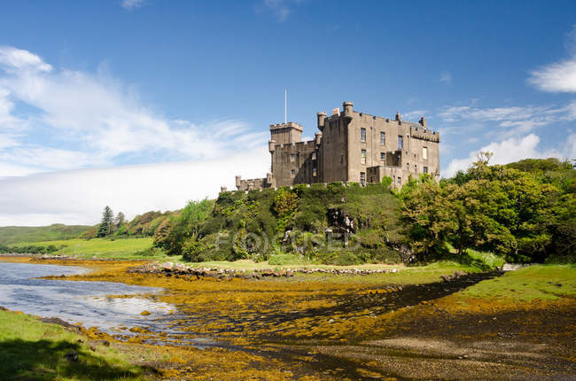 Reino Unido, Escocia, Highland, Isla de Skye, Dunvegan Castle on river bank - foto de stock
