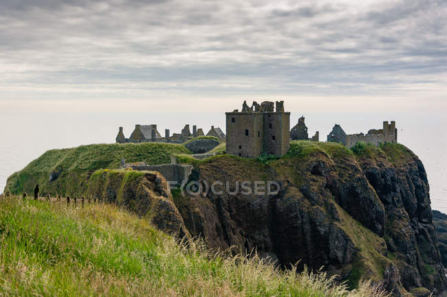 Reino Unido, Escocia, Aberdeenshire, Stonehaven, Dunnottar Castillo ruinas y edificios históricos en el acantilado junto al mar - foto de stock