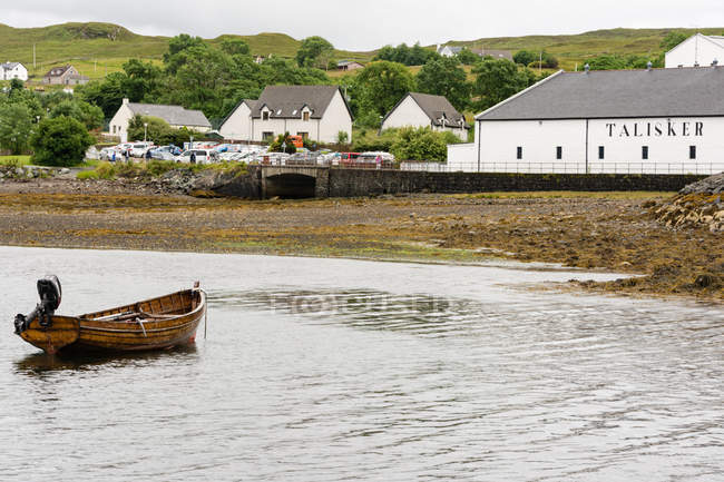 Reino Unido, Escocia, Highlands, Isla de Skye, Carbost, Talisker Distillery, pueblo en la orilla del lago - foto de stock