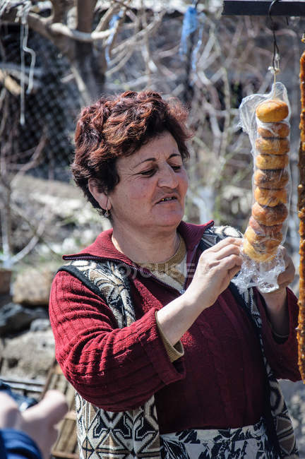 Mulher adulta vendendo rosquinhas no mercado de rua, Ohanavan, província de Aragatsotn, Armênia — Fotografia de Stock