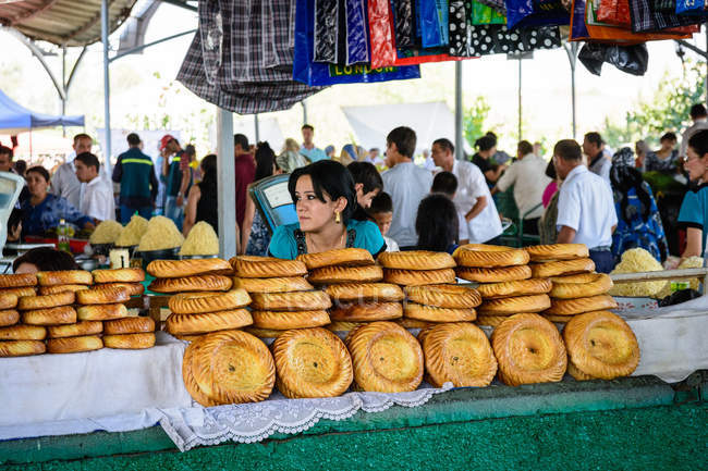 Porträt einer Frau, die auf dem Wochenmarkt in Taschkent, Usbekistan, traditionelles Brot verkauft — Stockfoto