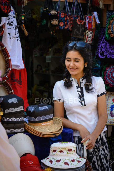 Woman at market stand with hats in Xiva, Xorazm province, Uzbekistan — Stock Photo
