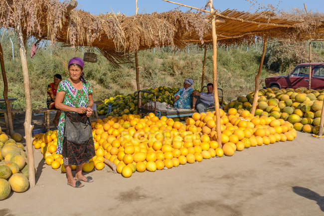 Uzbekistán, provincia de Buxoro, Jondor tumani, comerciantes de melón en carretera - foto de stock