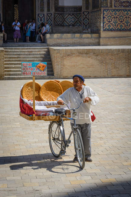 Ouzbékistan, Boukhara, Poi Kalon, homme avec pain et vélo — Photo de stock