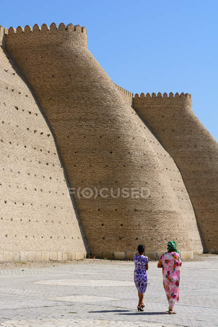 Uzbekistán, Provincia de Bujará, Bujará, Dos mujeres caminando en la ciudadela de Arca - foto de stock