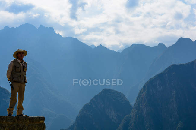 Человек, стоящий на скале, Перу, Куско, Урубамба, Мачу-Пикчу, объект мирового наследия ЮНЕСКО — стоковое фото