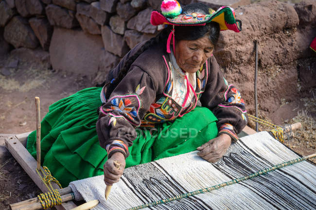 Peru, Puno, woman in traditional clothing spinning — Stock Photo