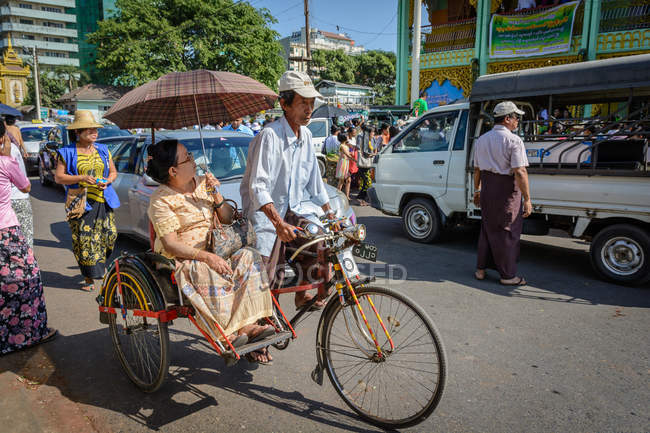 Myanmar, yangon region, yangon, frau mit schirm und mann auf fahrradbahn — Stockfoto