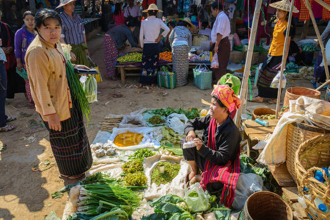Женщины в традиционных случайных закрытия на уличном рынке, Taunggyi, Шань, Мьянма — стоковое фото