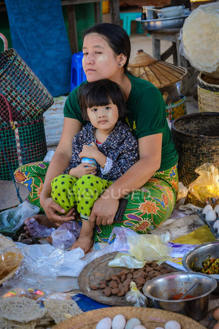 Женщина с дочерью на улице Phaung Daw U Pagoda рынке, Nyaungshwe, Шань, Мьянма — стоковое фото