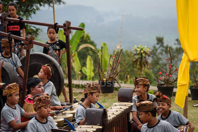 KABUL BULELENG, BALI, INDONESIA - 17 DE AGOSTO DE 2015: representación de la epopeya del Ramayana por la escuela de baile local, niños sentados en el suelo con ropa tradicional con instrumentos musicales - foto de stock