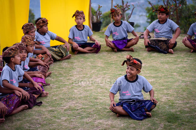 KABUL BULELENG, BALI, INDONESIA - 17 DE AGOSTO DE 2015: representación de la epopeya del Ramayana por la escuela de baile local, niños sentados en el suelo con ropa tradicional - foto de stock