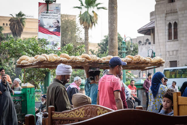 Egipto, provincia de El Cairo, El Cairo, hombre llevando pan en la cabeza en el bazar - foto de stock