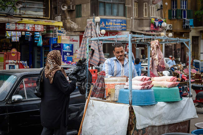 Egipto, Cairo Governorate, Cairo, mujer comprando carne en el bazar - foto de stock