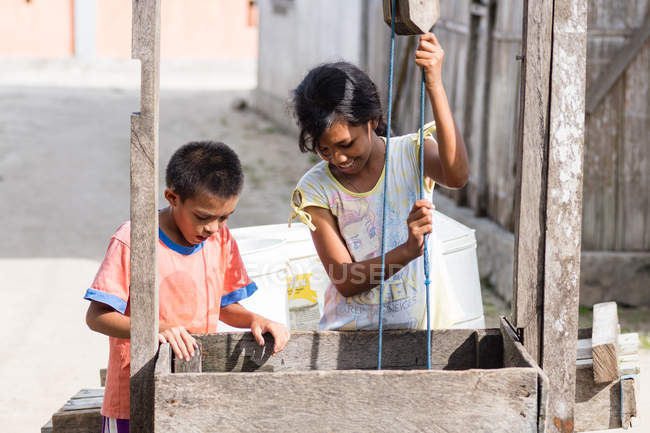 Indonesia, Maluku Utara, Kabul Pulau Morotai, niños locales en el pozo en Posiposi en el norte de Molikken - foto de stock