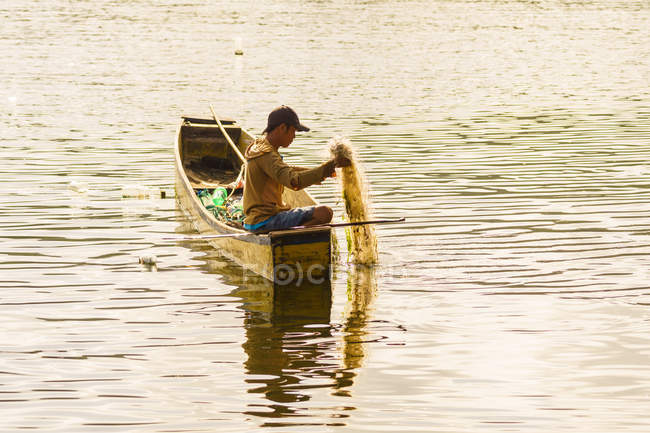 Indonesia, Sulawesi Utara, Kabupaten Minahasa, Fisherman trae la red alta, el lago Danau Tondano en Sulawesi Utara. - foto de stock