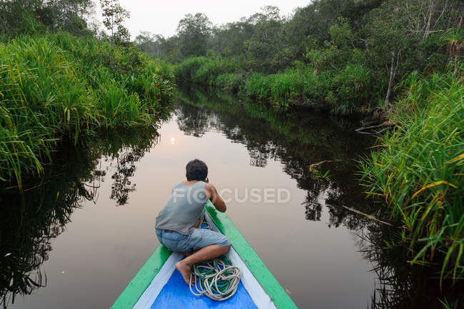 Indonesia, Kalimantan, Borneo, Kotawaringin Barat, hombre nadando en barco en el río Sekonyer - foto de stock