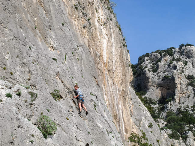 Сардиния, Италия - 20 октября 2013 года: Скалолаз на крутой скале из камня — стоковое фото