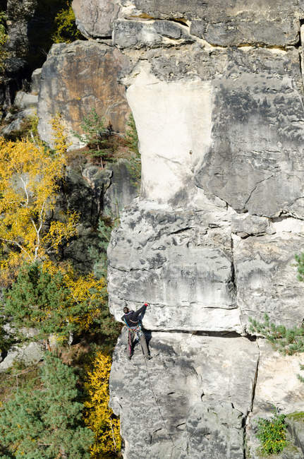 Germania, Sassonia, Svizzera sassone, tour di arrampicata sull'Hirschgrundkegel, arrampicatore nella vicina roccia, Vorderer Hirschgrundturm — Foto stock