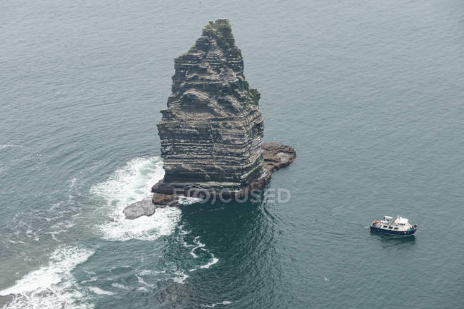 Irlanda, Contea di Clare, Cliffs of Moher, barca vicino ai massi in acqua — Foto stock