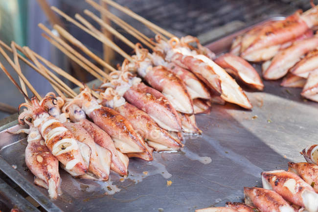 Gros plan des calmars grillés sur bâtonnets, marché du crabe de Kep — Photo de stock