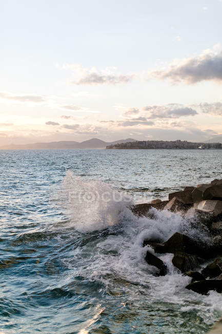 Griechenland, Attika, Paleo Faliro, Abend am Meer, Blick von der Hafenmauer auf Piräus und brechende Wellen — Stockfoto