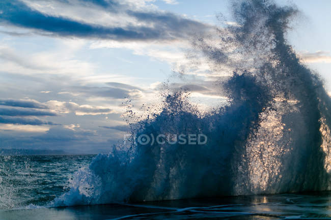 Griechenland, Attika, Paleo Faliro, brechende Wellen am Hafen im Abendlicht — Stockfoto