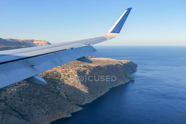 Griechenland, Flugzeug landet auf Beton, Teilansicht des Flügels über der Küstenlandschaft — Stockfoto